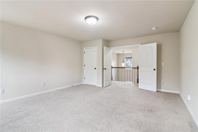 spare room featuring baseboards and carpet