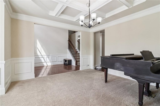 living area with carpet floors, ornamental molding, beam ceiling, a chandelier, and coffered ceiling