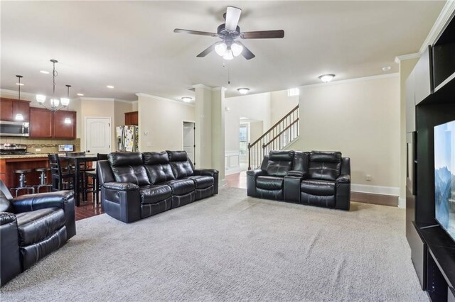 living area featuring crown molding, a ceiling fan, and carpet