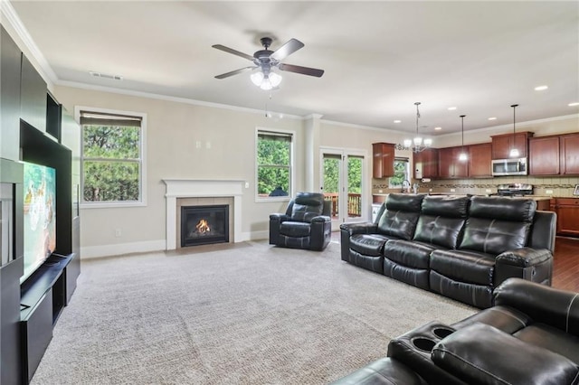 living area with a fireplace, ceiling fan with notable chandelier, recessed lighting, baseboards, and visible vents
