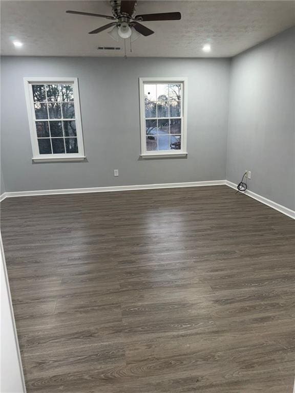 empty room featuring dark hardwood / wood-style flooring, a textured ceiling, and ceiling fan