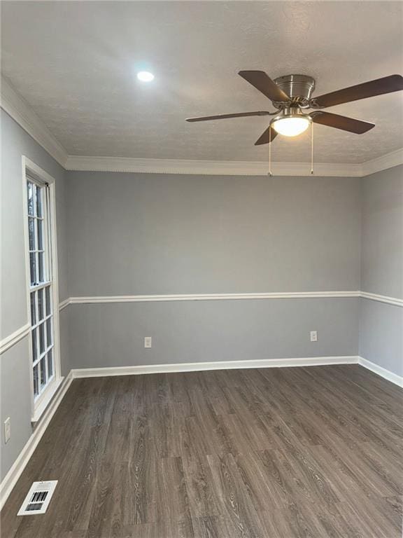 empty room with crown molding and dark hardwood / wood-style flooring