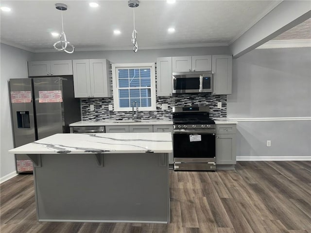 kitchen with crown molding, appliances with stainless steel finishes, gray cabinets, pendant lighting, and light stone countertops