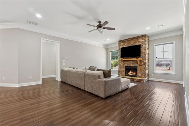 2040 Birchdale Dr, Milton, GA 30004 - living room featuring crown molding, a ceiling fan, dark wood-type flooring, a stone fireplace, and baseboards