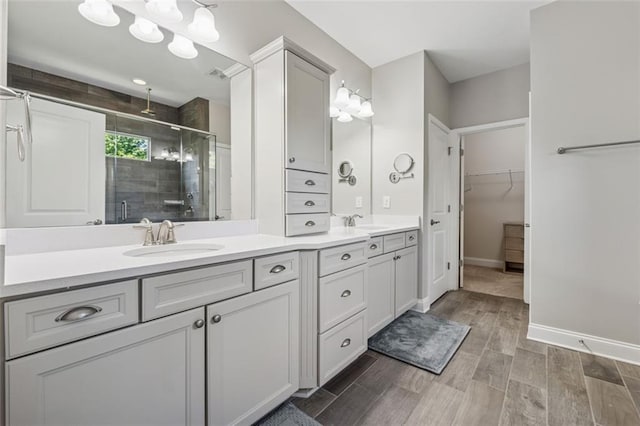 2040 Birchdale Dr, Milton, GA 30004 - full bathroom with a stall shower, double vanity, wood finished floors, a walk in closet, and baseboards