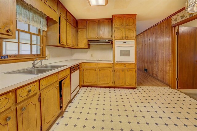 1830 Francis Rd SW, Conyers, GA 30094 - kitchen with white appliances, light floors, brown cabinetry, light countertops, and wood walls