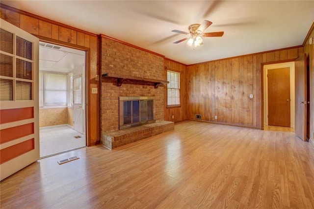 1830 Francis Rd SW, Conyers, GA 30094 - unfurnished living room featuring ceiling fan, plenty of natural light, a fireplace, crown molding, and light wood-style floors