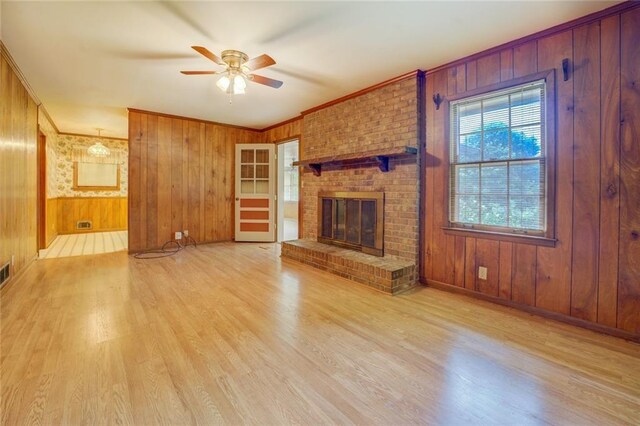 1830 Francis Rd SW, Conyers, GA 30094 - unfurnished living room with a ceiling fan, wood finished floors, wood walls, crown molding, and a brick fireplace