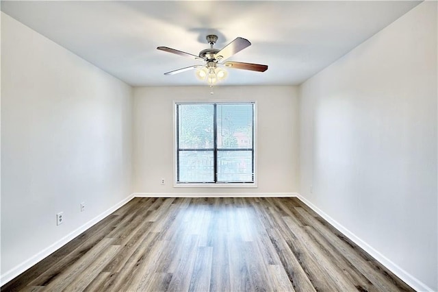 unfurnished room featuring ceiling fan, dark wood-style flooring, and baseboards