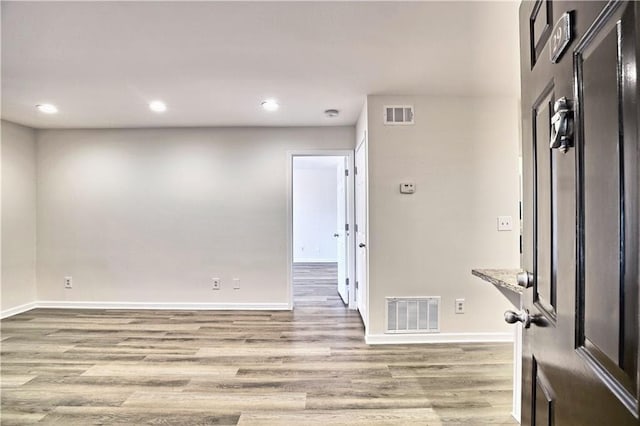 spare room with recessed lighting, visible vents, light wood-style flooring, and baseboards