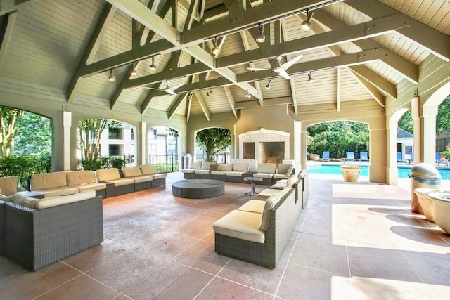 exterior space featuring an outdoor living space with a fireplace, an outdoor pool, and a gazebo