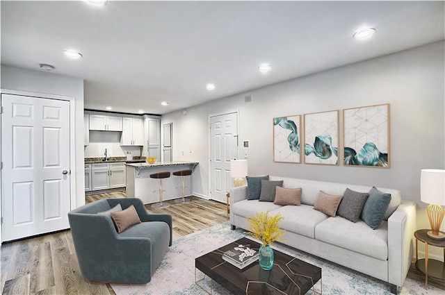 living room featuring light wood finished floors and recessed lighting