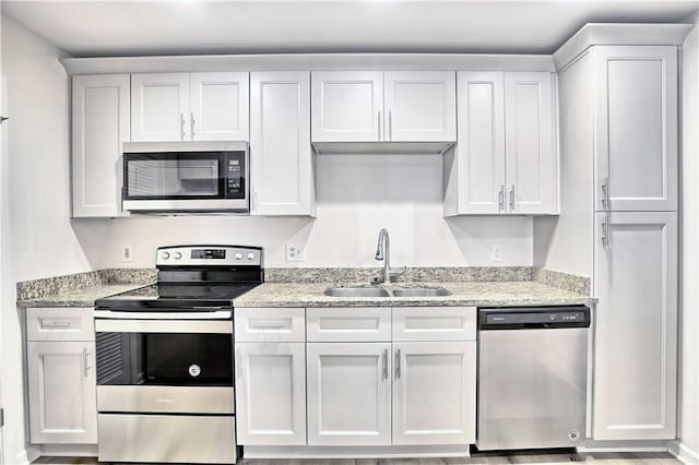 kitchen featuring stainless steel appliances, white cabinets, and a sink