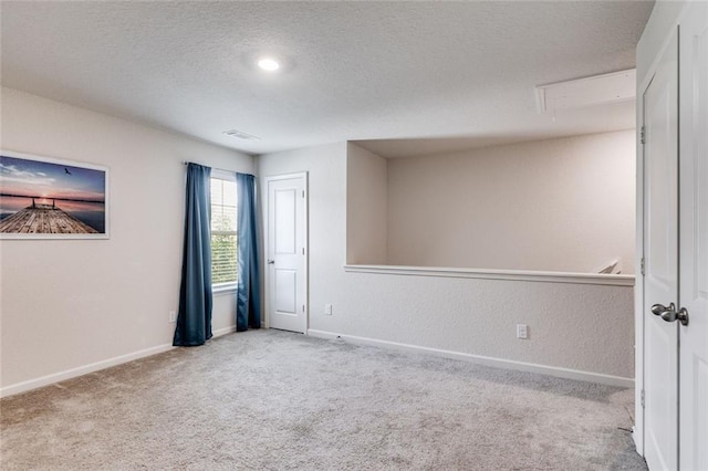 unfurnished room with light carpet and a textured ceiling