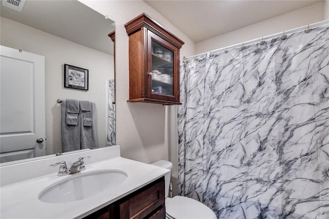 bathroom with a shower with shower curtain, vanity, and toilet