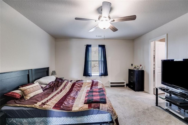 bedroom with light carpet, a textured ceiling, and ceiling fan