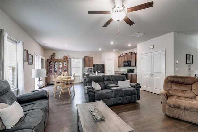 living room with dark hardwood / wood-style floors and ceiling fan