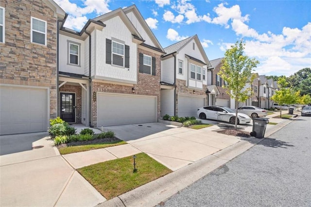 multi unit property featuring a garage, a residential view, concrete driveway, and brick siding