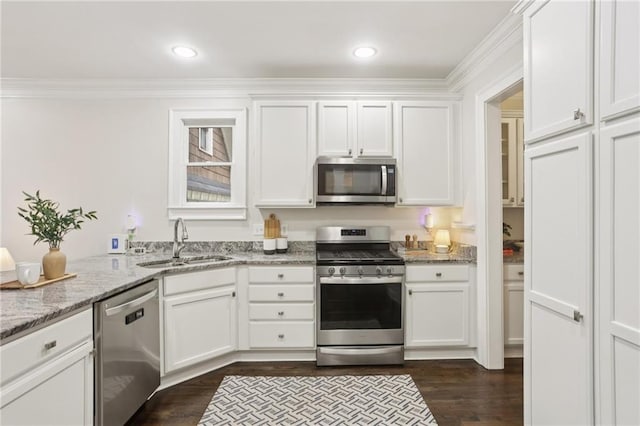 47 Oakridge Ave SE, Atlanta, GA 30317 - kitchen with appliances with stainless steel finishes, white cabinets, light stone counters, dark wood-type flooring, and crown molding