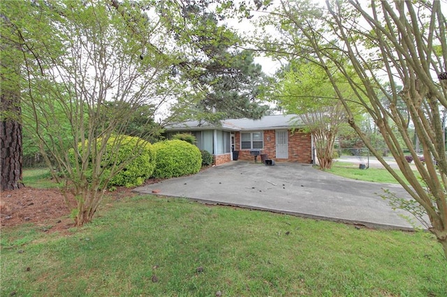 rear view of house featuring brick siding and a yard