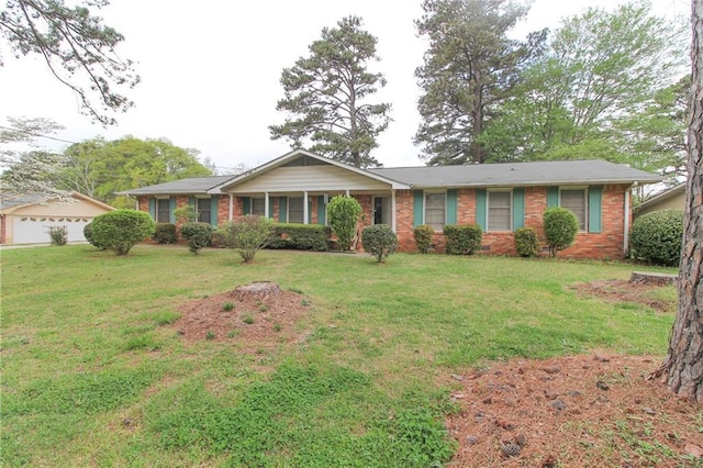 ranch-style home with brick siding, a front yard, and a detached garage