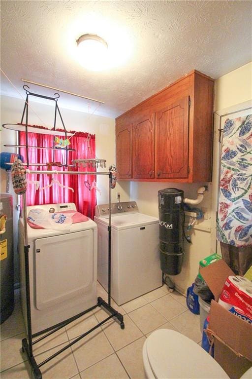 laundry area with a textured ceiling, washing machine and clothes dryer, light tile patterned floors, and laundry area