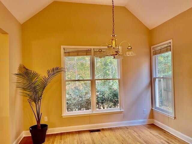 foyer entrance featuring a chandelier, hardwood / wood-style flooring, a tray ceiling, and crown molding