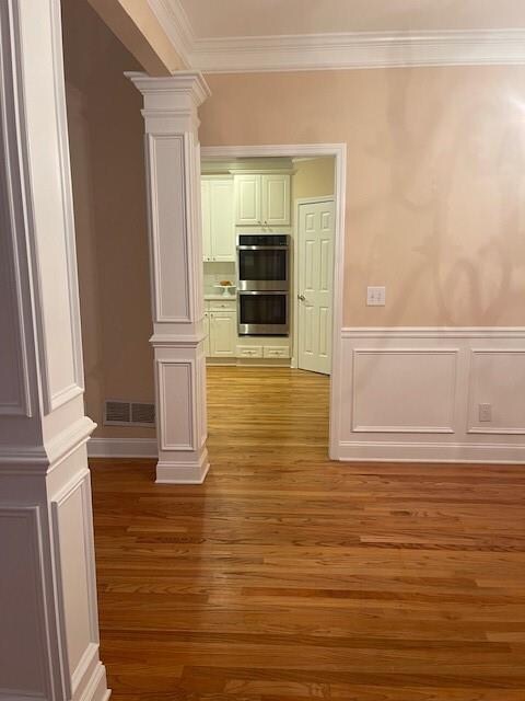 unfurnished room featuring ornamental molding and light hardwood / wood-style flooring