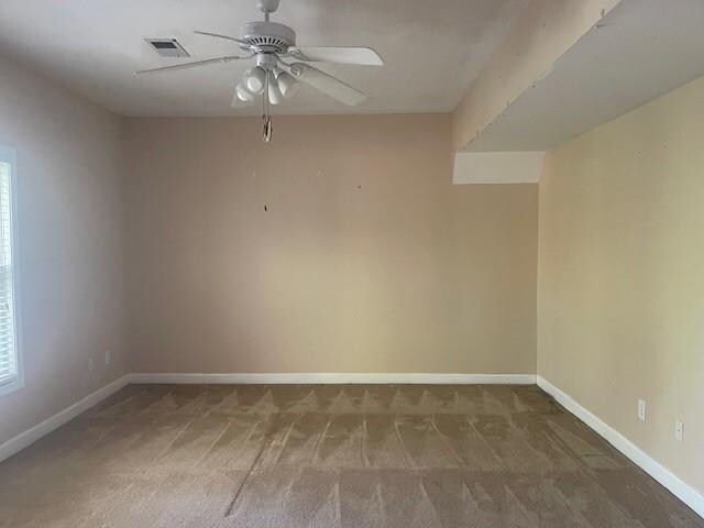 unfurnished dining area featuring a drop ceiling and light colored carpet