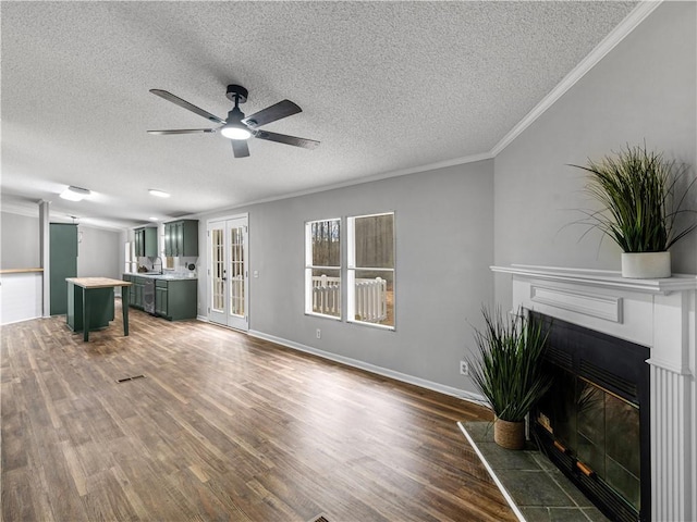 unfurnished living room featuring a fireplace with raised hearth, dark wood-style flooring, baseboards, and crown molding