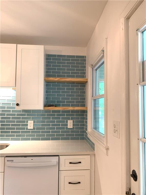 3604 Orchard Cir, Decatur, GA 30032 - kitchen with white dishwasher, tasteful backsplash, white cabinetry, and light countertops