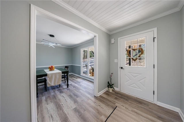 foyer with crown molding, baseboards, and wood finished floors