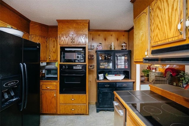 kitchen with black appliances, tile countertops, brown cabinets, and a textured ceiling