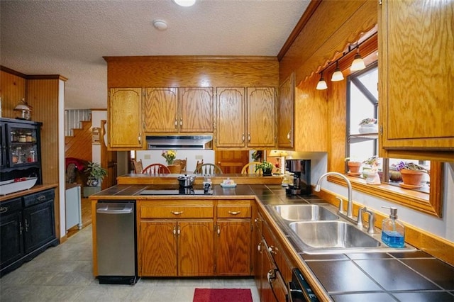 kitchen featuring tile countertops, black electric cooktop, brown cabinets, and a sink