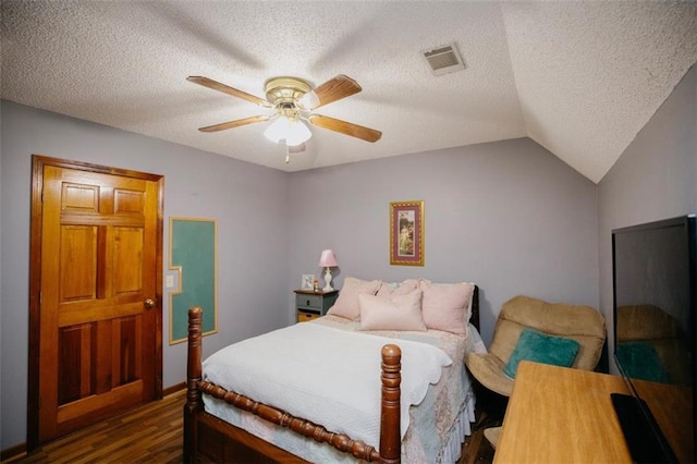 bedroom with vaulted ceiling, dark wood-style floors, visible vents, and a textured ceiling