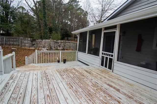 wooden deck with a sunroom and fence