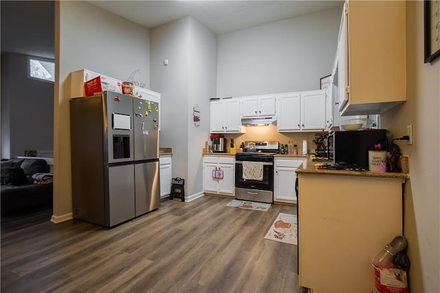 kitchen featuring white cabinets, dark wood-style floors, appliances with stainless steel finishes, a high ceiling, and under cabinet range hood