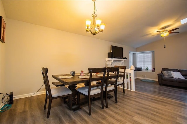 dining space with lofted ceiling, baseboards, wood finished floors, and ceiling fan with notable chandelier