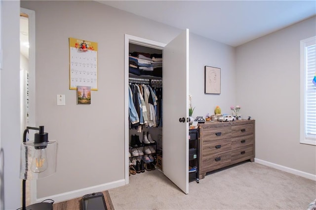 bedroom with light carpet, a closet, and baseboards