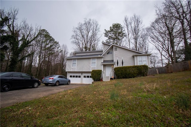 view of front facade featuring a garage, driveway, a front lawn, and a chimney