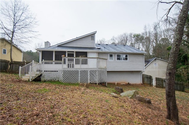 back of property with a sunroom, a fenced backyard, a chimney, and a wooden deck