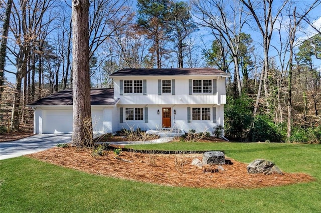 view of front of property with an attached garage, a front lawn, and concrete driveway