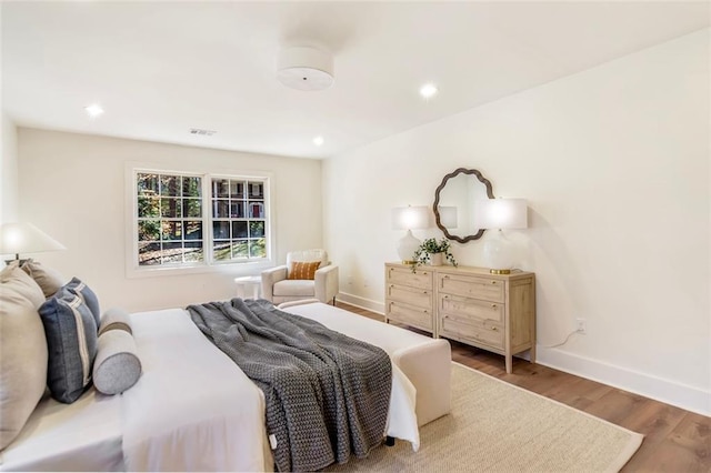 bedroom with recessed lighting, wood finished floors, visible vents, and baseboards