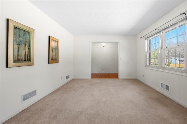 carpeted empty room with visible vents and baseboards