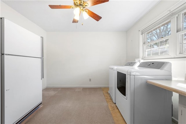 washroom featuring a ceiling fan, light carpet, washer and dryer, laundry area, and baseboards