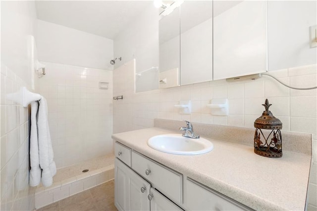 full bathroom with backsplash, a tile shower, and vanity