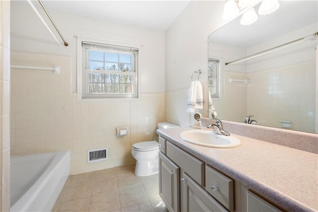 full bathroom with visible vents, toilet, tile patterned flooring, vanity, and tile walls