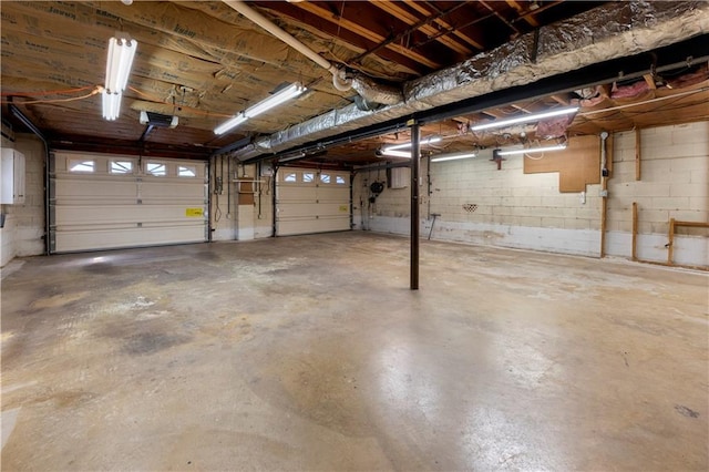 garage featuring concrete block wall and a garage door opener