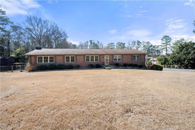 single story home with brick siding and a front lawn