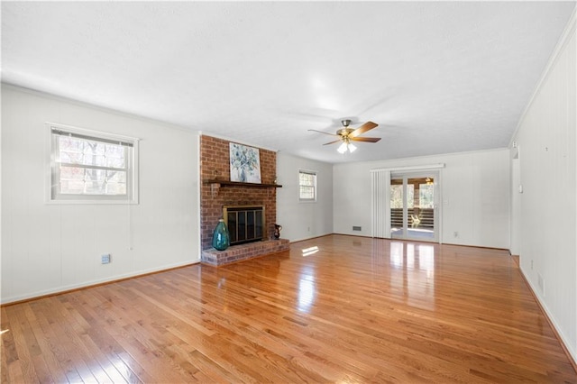 unfurnished living room with a fireplace, light wood finished floors, and ceiling fan